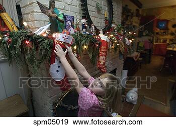 Stock Photograph - young girl hanging 
up christmas stocking. 
fotosearch - search 
stock photos, 
pictures, images, 
and photo clipart