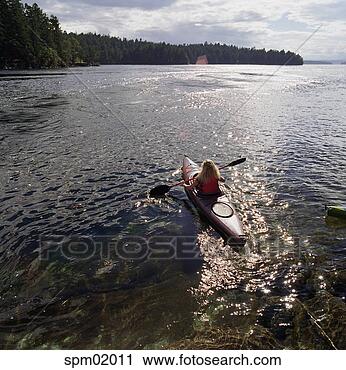 Stock Photography - young girl kayaking 
in lake. fotosearch 
- search stock 
photos, pictures, 
images, and photo 
clipart