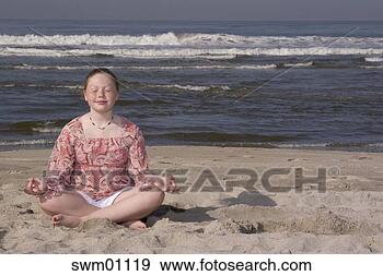 Stock Photograph - young girl meditating 
on beach. fotosearch 
- search stock 
photos, pictures, 
images, and photo 
clipart