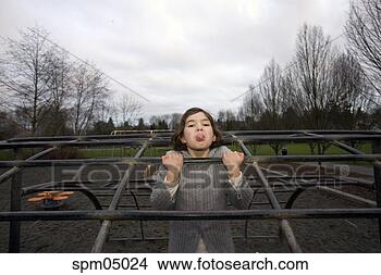 Stock Photo - young girl sticking 
out tongue on 
jungle gym. fotosearch 
- search stock 
photos, pictures, 
images, and photo 
clipart