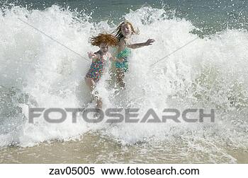 Stock Image - young girls playing 
in waves at beach. 
fotosearch - search 
stock photos, 
pictures, images, 
and photo clipart