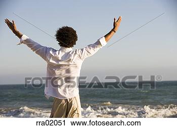 Stock Photography - young man reaching 
arms out to sea. 
fotosearch - search 
stock photos, 
pictures, images, 
and photo clipart