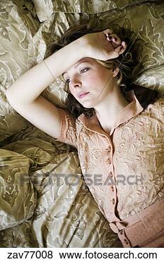 Stock Photo - young woman laying 
on bed. fotosearch 
- search stock 
photos, pictures, 
images, and photo 
clipart