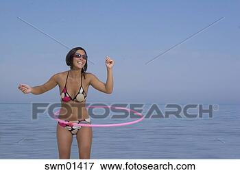 Picture - young woman playing 
with hula-hoop 
on beach. fotosearch 
- search stock 
photos, pictures, 
images, and photo 
clipart