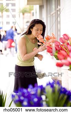 Stock Photography - young woman smelling 
flowers at outdoor 
flower market. 
fotosearch - search 
stock photos, 
pictures, images, 
and photo clipart