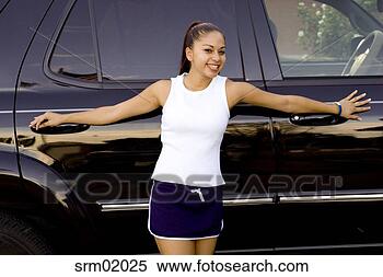 Stock Image - young woman smiling 
in front of sport 
utility vehicle. 
fotosearch - search 
stock photos, 
pictures, images, 
and photo clipart