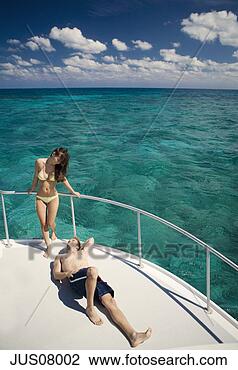 Stock Photo - couple sunbathing 
on boat. fotosearch 
- search stock 
photos, pictures, 
images, and photo 
clipart