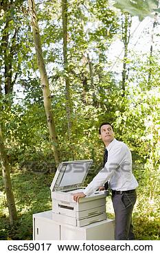 Picture - businessman leaning 
on copier in woods. 
fotosearch - search 
stock photos, 
pictures, images, 
and photo clipart
