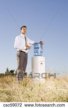 Stock Photo - businessman next 
to water cooler 
in field. fotosearch 
- search stock 
photos, pictures, 
images, and photo 
clipart