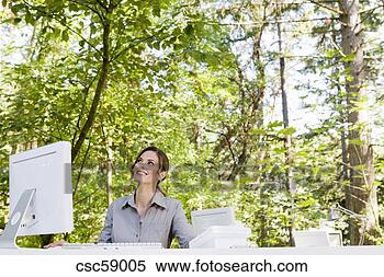 Stock Image - businesswoman 
at desk in woods. 
fotosearch - search 
stock photos, 
pictures, images, 
and photo clipart