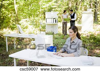 Picture - businesswoman 
at desk in woods. 
fotosearch - search 
stock photos, 
pictures, images, 
and photo clipart