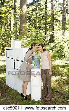 Stock Photography - businesswomen 
talking at water 
cooler in woods. 
fotosearch - search 
stock photos, 
pictures, images, 
and photo clipart