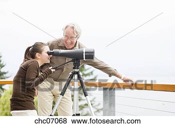 Stock Photo - grandfather and 
granddaughter 
looking through 
telescope. fotosearch 
- search stock 
photos, pictures, 
images, and photo 
clipart