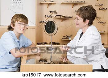 Picture - female optician 
with boy in office. 
fotosearch - search 
stock photos, 
pictures, images, 
and photo clipart