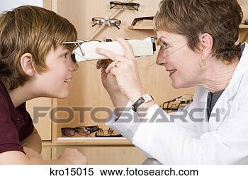 Stock Image - female optician 
examining boy. 
fotosearch - search 
stock photos, 
pictures, images, 
and photo clipart