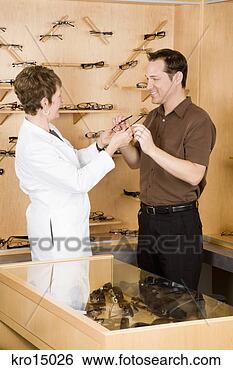 Stock Photo - female optician 
giving eyeglasses 
to man. fotosearch 
- search stock 
photos, pictures, 
images, and photo 
clipart