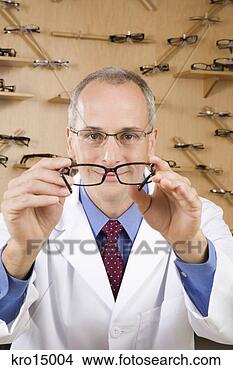 Stock Photo - male optician 
holding eye glasses. 
fotosearch - search 
stock photos, 
pictures, images, 
and photo clipart
