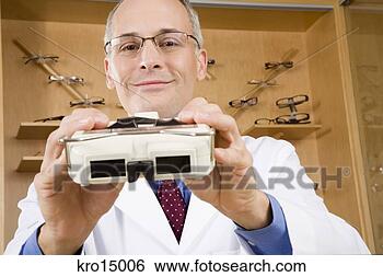 Stock Photo - male optician 
holding diagnostic 
tool. fotosearch 
- search stock 
photos, pictures, 
images, and photo 
clipart