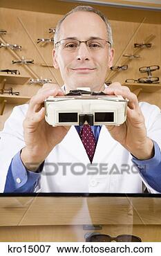 Picture - male optician 
holding diagnostic 
tool. fotosearch 
- search stock 
photos, pictures, 
images, and photo 
clipart