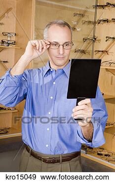 Stock Photograph - man trying on 
eyeglasses. fotosearch 
- search stock 
photos, pictures, 
images, and photo 
clipart