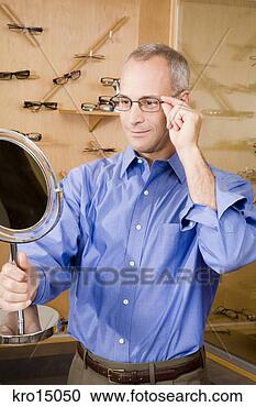 Stock Photography - man trying on 
eyeglasses. fotosearch 
- search stock 
photos, pictures, 
images, and photo 
clipart