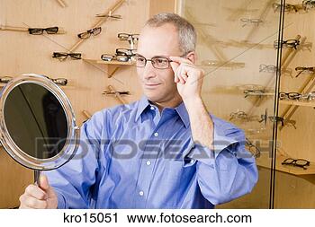 Stock Photography - man trying on 
eyeglasses. fotosearch 
- search stock 
photos, pictures, 
images, and photo 
clipart