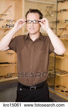 Stock Photography - man trying on 
eyeglasses. fotosearch 
- search stock 
photos, pictures, 
images, and photo 
clipart