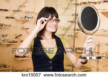 Picture - woman trying on 
eyeglasses. fotosearch 
- search stock 
photos, pictures, 
images, and photo 
clipart