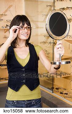 Stock Photo - woman trying on 
eyeglasses. fotosearch 
- search stock 
photos, pictures, 
images, and photo 
clipart