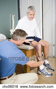 Stock Photo - physical therapist 
examining man’s 
leg. fotosearch 
- search stock 
photos, pictures, 
images, and photo 
clipart