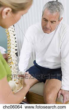 Stock Photo - physical therapist 
and patient looking 
at spine model. 
fotosearch - search 
stock photos, 
pictures, images, 
and photo clipart