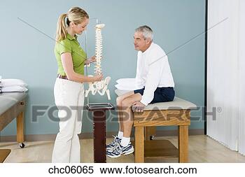 Stock Image - physical therapist 
and patient looking 
at spine model. 
fotosearch - search 
stock photos, 
pictures, images, 
and photo clipart