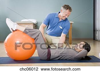 Stock Photo - physical trainer 
helping woman 
exercise. fotosearch 
- search stock 
photos, pictures, 
images, and photo 
clipart