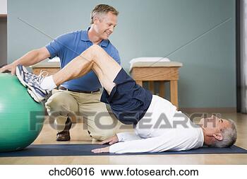 Stock Photo - physical trainer 
helping man exercise. 
fotosearch - search 
stock photos, 
pictures, images, 
and photo clipart