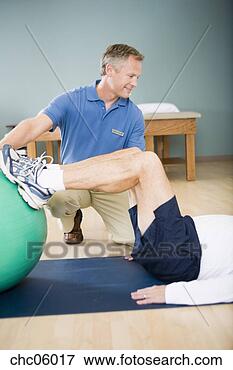 Picture - physical trainer 
helping man exercise. 
fotosearch - search 
stock photos, 
pictures, images, 
and photo clipart
