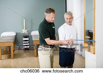 Stock Photo - physical trainer 
helping man exercise. 
fotosearch - search 
stock photos, 
pictures, images, 
and photo clipart