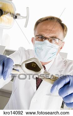 Stock Photo - male dentist holding 
oxygen mask. fotosearch 
- search stock 
photos, pictures, 
images, and photo 
clipart