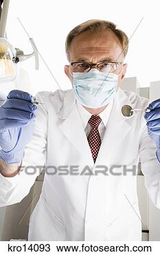 Stock Photo - male dentist holding 
dental tools. 
fotosearch - search 
stock photos, 
pictures, images, 
and photo clipart