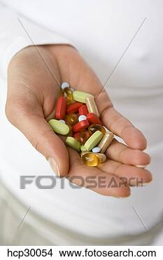 Stock Photo - woman holding 
a handful of capsules. 
fotosearch - search 
stock photos, 
pictures, images, 
and photo clipart