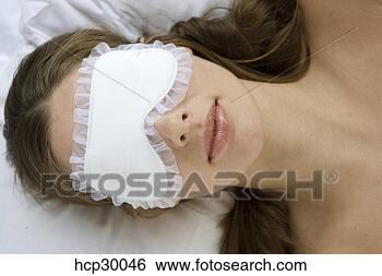 Stock Photo - young woman lying 
down wearing sleeping 
mask. fotosearch 
- search stock 
photos, pictures, 
images, and photo 
clipart