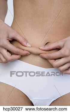 Picture - young woman pinching 
her stomach. fotosearch 
- search stock 
photos, pictures, 
images, and photo 
clipart