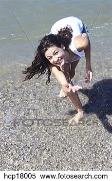 Stock Image - young woman spashing 
at beach. fotosearch 
- search stock 
photos, pictures, 
images, and photo 
clipart