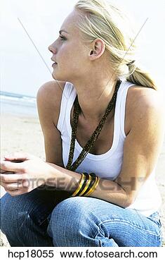 Stock Image - young woman squatting 
at beach. fotosearch 
- search stock 
photos, pictures, 
images, and photo 
clipart