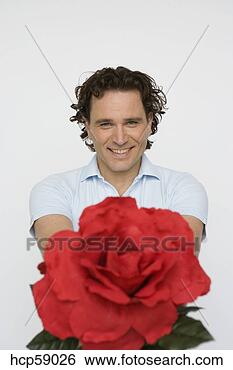 Stock Photo - man holding out 
oversized flower. 
fotosearch - search 
stock photos, 
pictures, images, 
and photo clipart