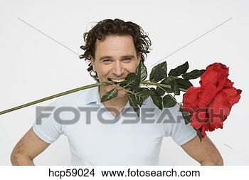 Stock Photo - man holding oversized 
flower between 
his teeth. fotosearch 
- search stock 
photos, pictures, 
images, and photo 
clipart