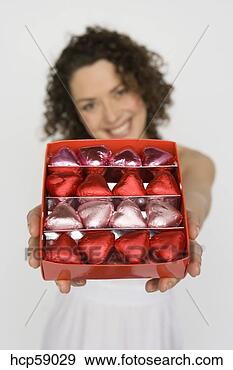 Stock Photograph - woman holding 
out box of chocolates. 
fotosearch - search 
stock photos, 
pictures, images, 
and photo clipart