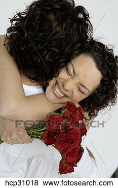 Stock Photo - young man embracing 
young woman with 
bouquet of roses. 
fotosearch - search 
stock photos, 
pictures, images, 
and photo clipart
