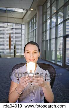 Stock Photograph - businesswoman 
holding energy 
efficient light 
bulb. fotosearch 
- search stock 
photos, pictures, 
images, and photo 
clipart