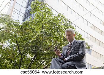 Stock Photo - businessman looking 
at cell phone. 
fotosearch - search 
stock photos, 
pictures, images, 
and photo clipart