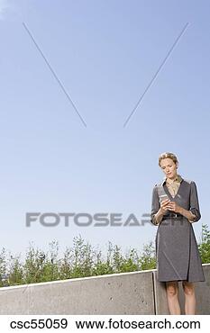 Stock Photograph - businesswoman 
looking at cell 
phone. fotosearch 
- search stock 
photos, pictures, 
images, and photo 
clipart
